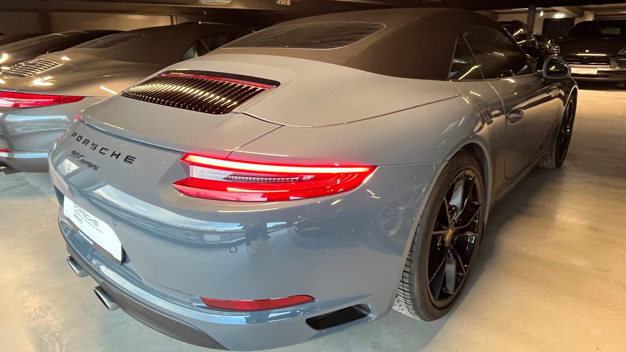 Porsche 911 type 991 phase 2 Carrera Cabriolet bleu graphite en Allemagne vue de la ligne de feux arrières